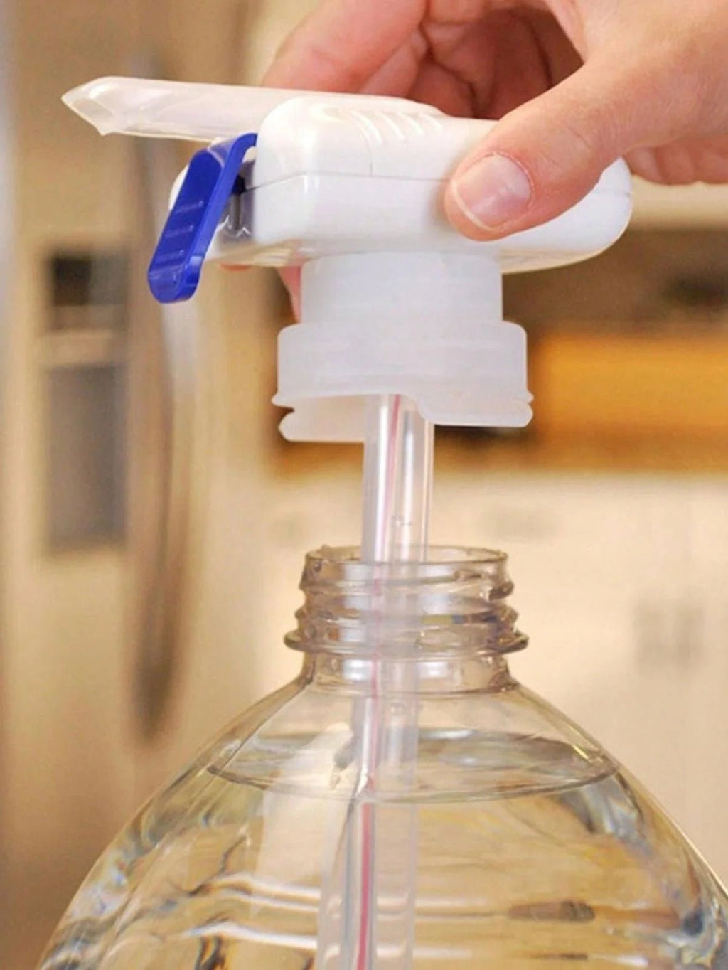 Hand holding an automatic beverage dispenser on a clear bottle with a blurred background